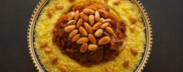 Moroccan Riviera Menu Marrakech: Chicken couscous with tfaya (caramelized onions and raisins) topped with toasted almonds on a Moroccan ceramic plate