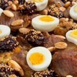 Traditional Moroccan lamb tagine with onions and raisins served in a clay pot