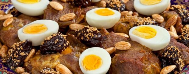 Traditional Moroccan lamb tagine with onions and raisins served in a clay pot